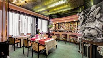 Un ristorante con tavoli e sedie, una zona bar e una scultura decorativa.