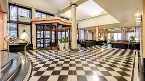 A lobby with a checkered floor, a reception desk, and a seating area. - Hotel Brunelleschi (Milan)