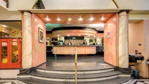 A hotel lobby with a curved reception desk, marble columns, and a check-in counter. - Hotel Brunelleschi (Milan)