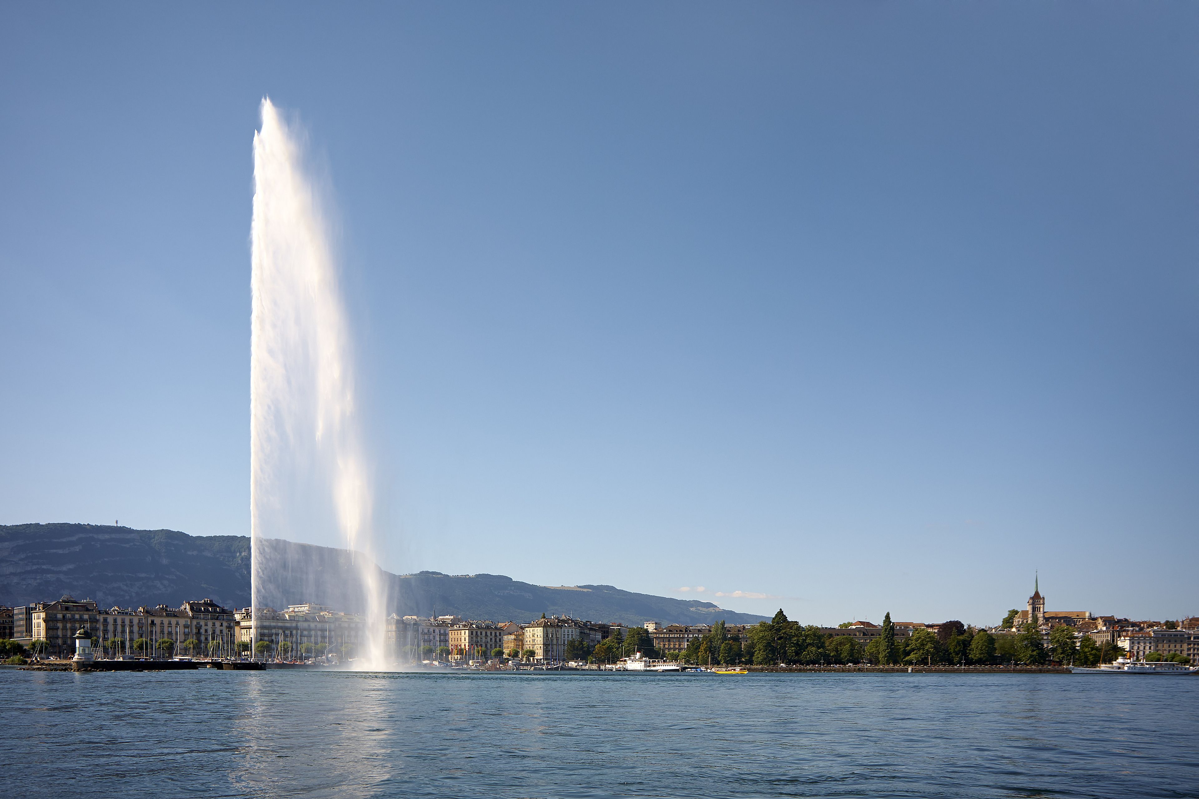 Une vue urbaine avec une fontaine imposante au premier plan et une église en arrière-plan.
