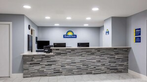 A reception desk with a Days Inn logo, a flat-screen TV, and a digital kiosk. - Days Inn by Wyndham Granbury (Granbury)