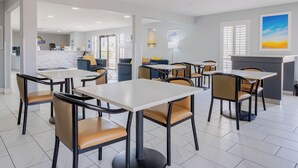 A modern hotel lobby with a reception desk, seating area, and artwork on the walls. - Days Inn by Wyndham Granbury (Granbury)