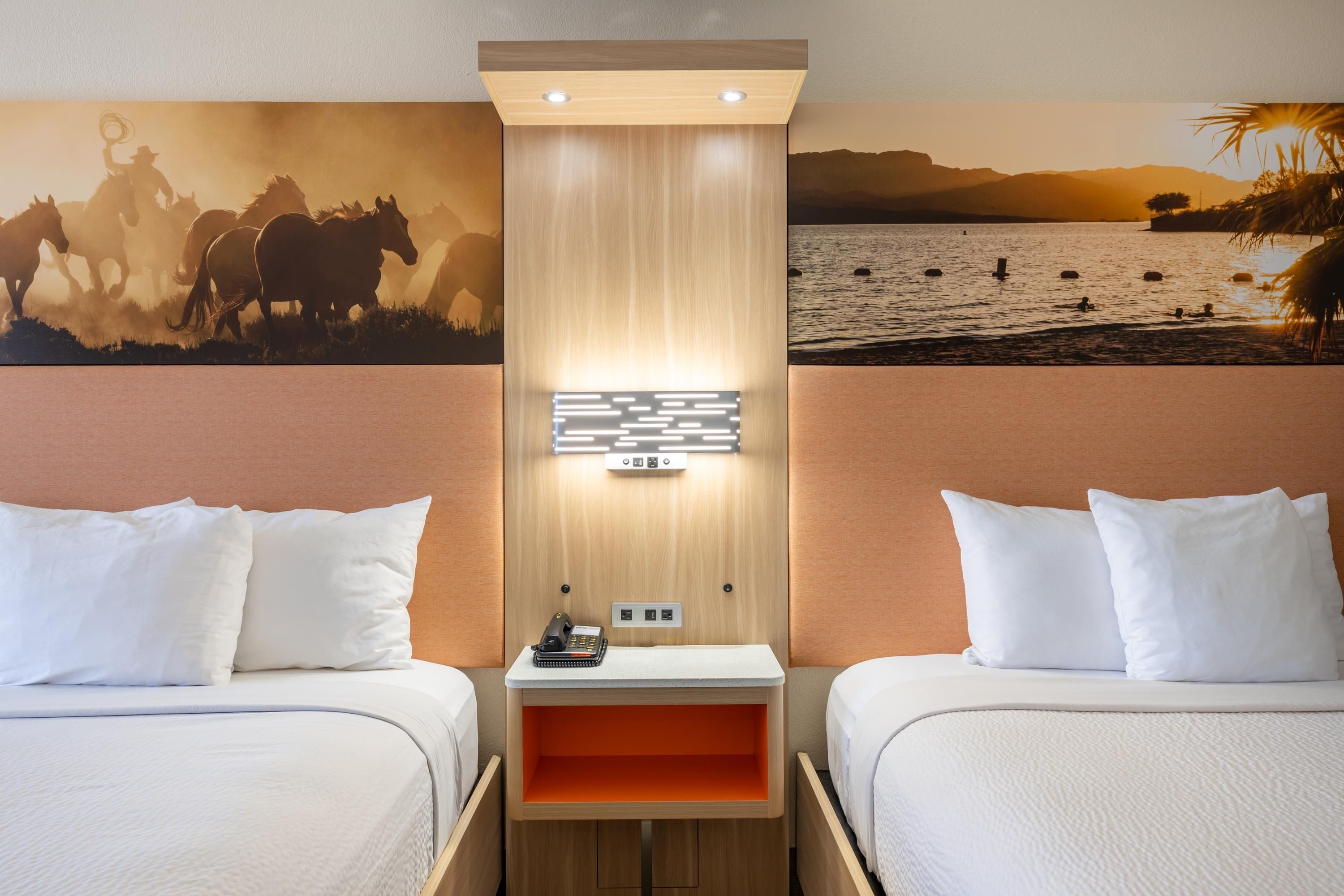 Ein Hotelzimmer mit zwei Betten, einem Nachttisch mit Telefon und einer Wandleuchte.