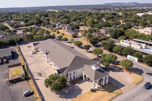 An aerial view of a residential area with houses, a parking lot, and a Days Inn hotel. - Days Inn by Wyndham Granbury (Granbury)