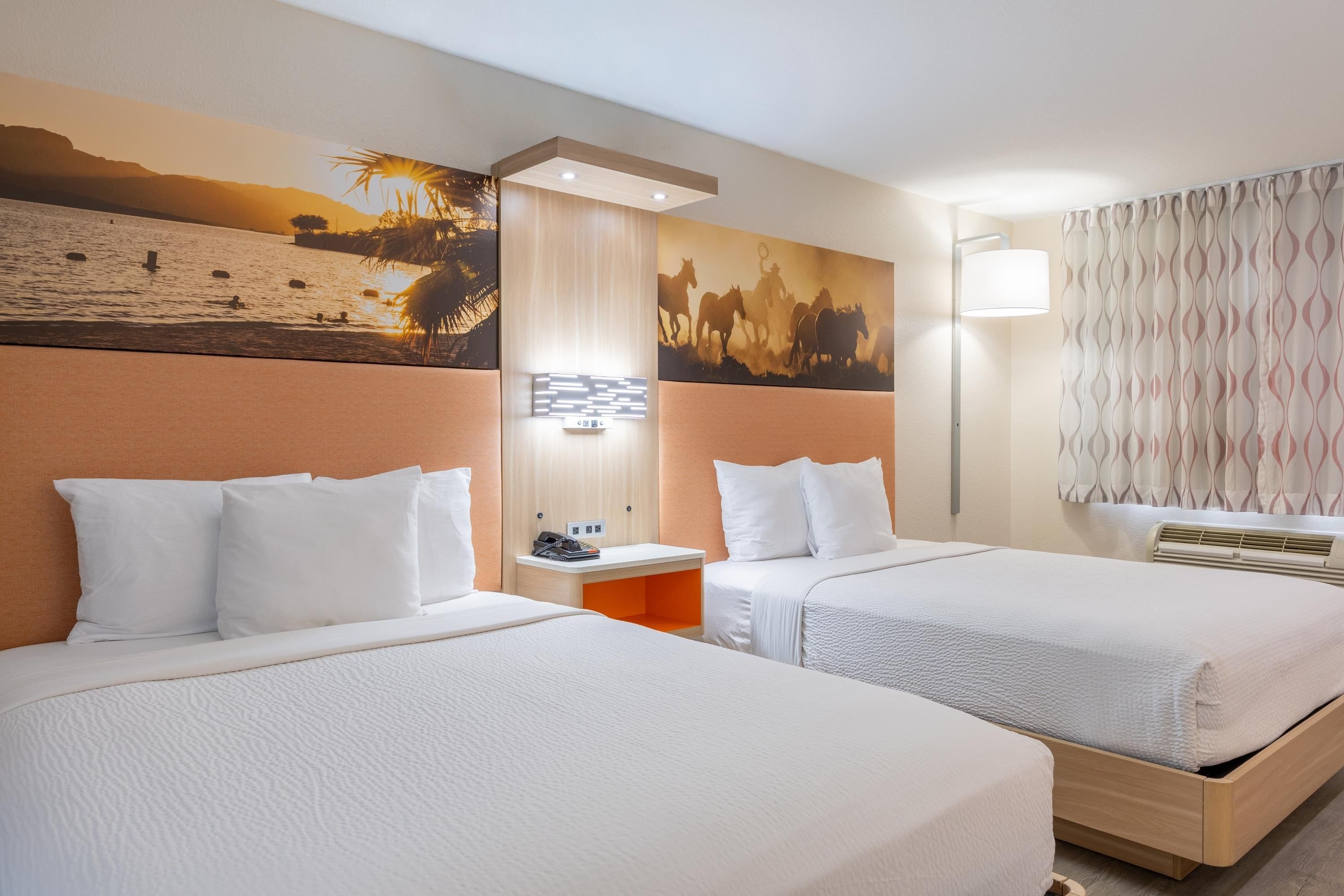 Ein Hotelzimmer mit zwei Betten, einem Nachttisch, einer Wandlampe und einem großen Gemälde.