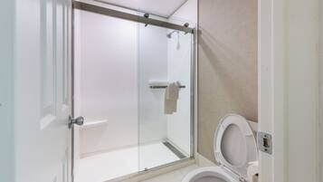 Ein modernes Badezimmer mit einer einteiligen Duschkabine, Toilette und Handtuchhalter.