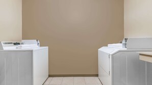 A laundry room with two white washing machines and a control panel. - Days Inn by Wyndham Granbury (Granbury)