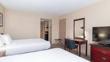 Habitación de hotel con dos camas, un escritorio, una silla, un televisor y un aparador.