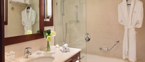 Un baño moderno con lavamanos, espejo y ducha.