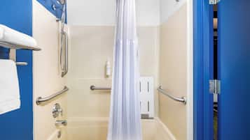A bathroom with a bathtub, grab bars, a shower curtain, and a towel rack.