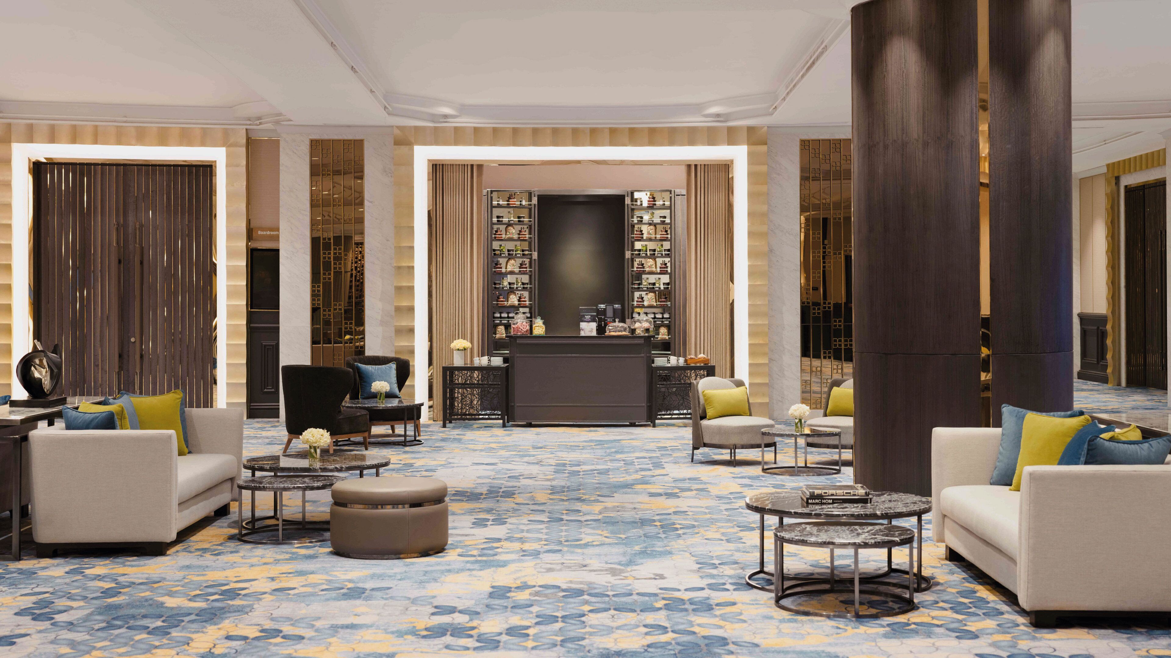 A spacious lobby with a central bar area, seating arrangements, and a patterned carpet.