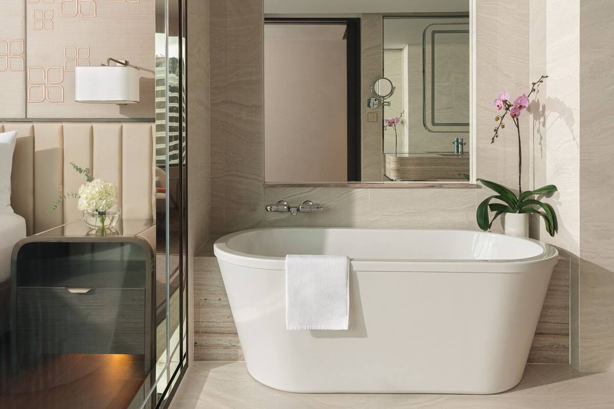 A modern bathroom with a freestanding bathtub, a glass shower enclosure, and a vanity with a mirror.