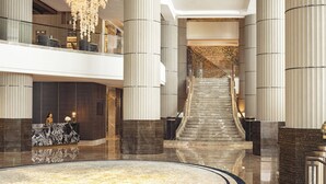 A spacious lobby with a grand staircase, marble reception desk, and modern lighting fixtures. - InterContinental Bangkok by IHG (Bangkok)