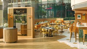 Un restaurante en el sur de California con una decoración moderna, que incluye detalles de madera y diversas opciones de asientos.