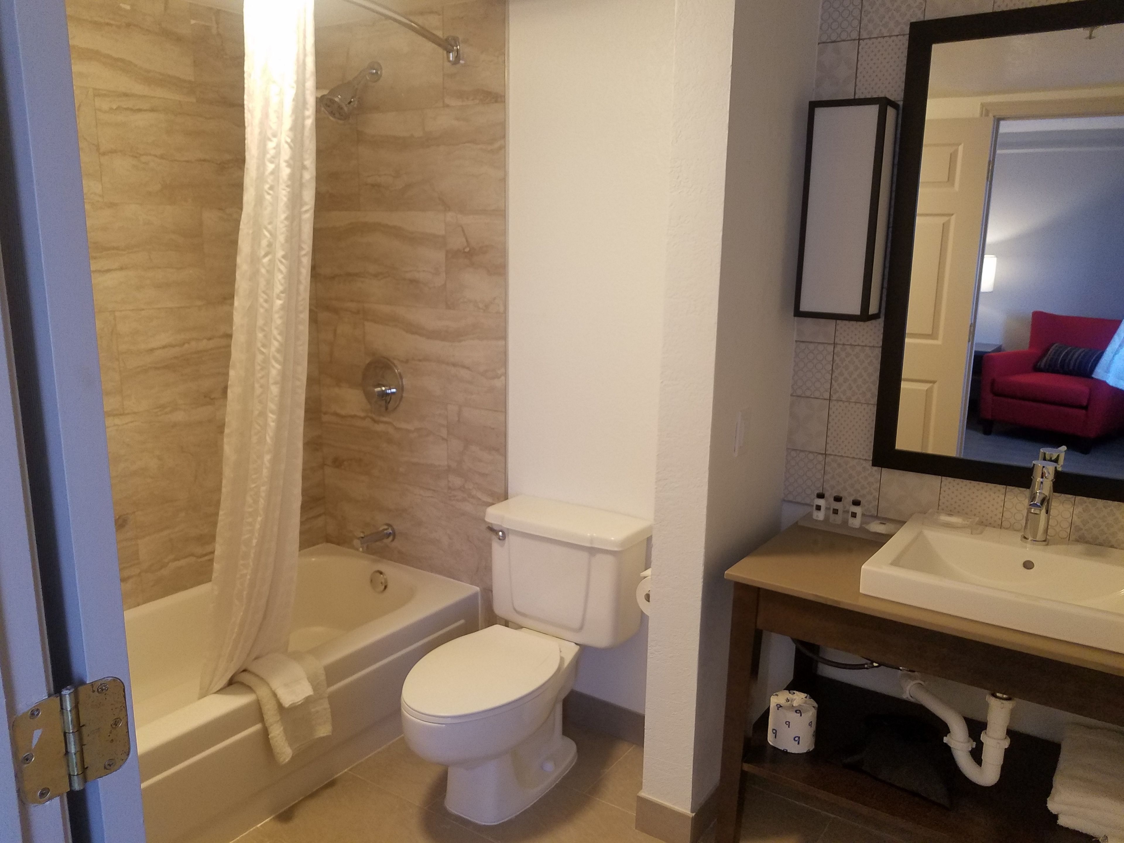 A bathroom with a bathtub, toilet, and sink.