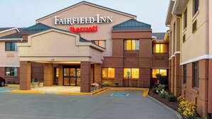 Un hôtel Fairfield Inn Marriott doté d’une façade moderne, d’une entrée bien éclairée et d’un parking avec des places délimitées.
