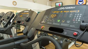 A row of Life Fitness treadmills in a gym, each with a control panel displaying various workout options.