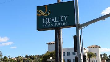 Une enseigne pour le Quality Inn & Suites, offrant une vue dégagée sur les bâtiments et la rue environnants.