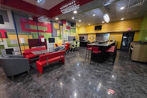 A modern restaurant with a colorful geometric wall design, marble flooring, and red and grey seating. - Quality Inn Cairo (Cairo)