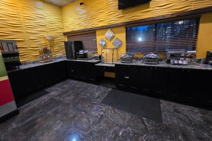 Una cocina moderna con encimeras de granito, microondas, tostadora y cafetera.