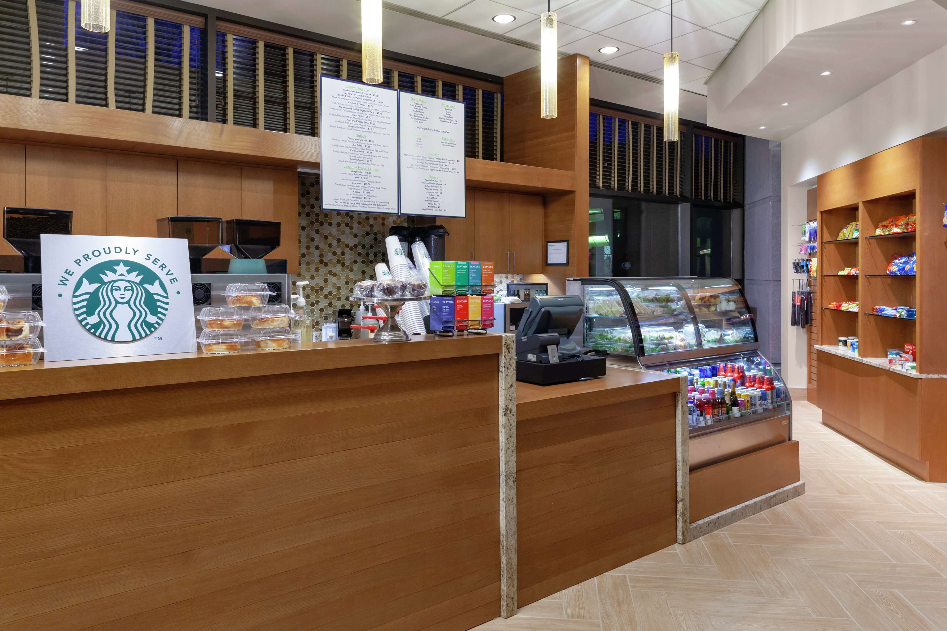 A Starbucks counter with a menu board, a coffee machine, and a display case with beverages.