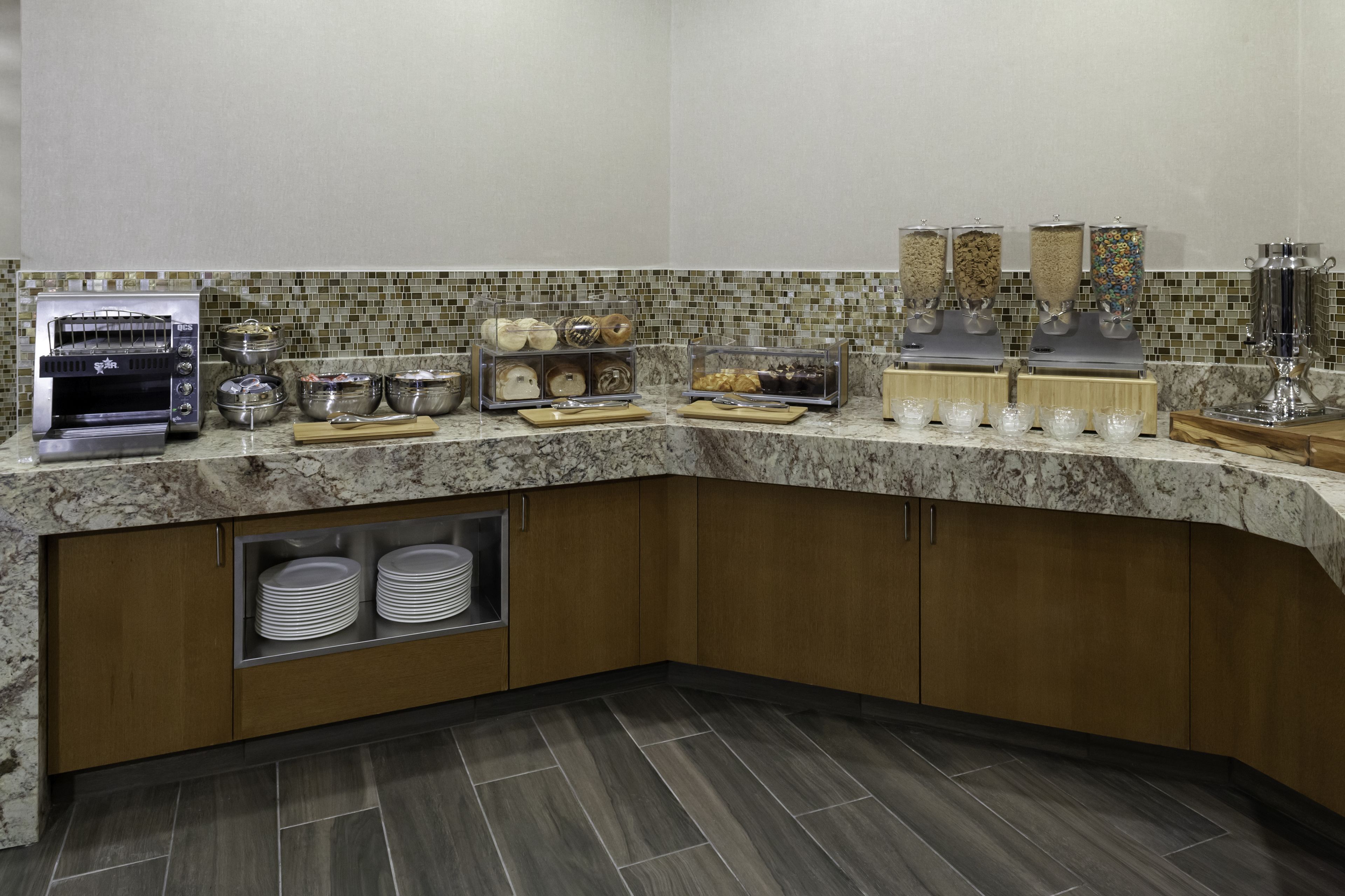 A breakfast bar with a toaster, bowls, and a coffee machine.