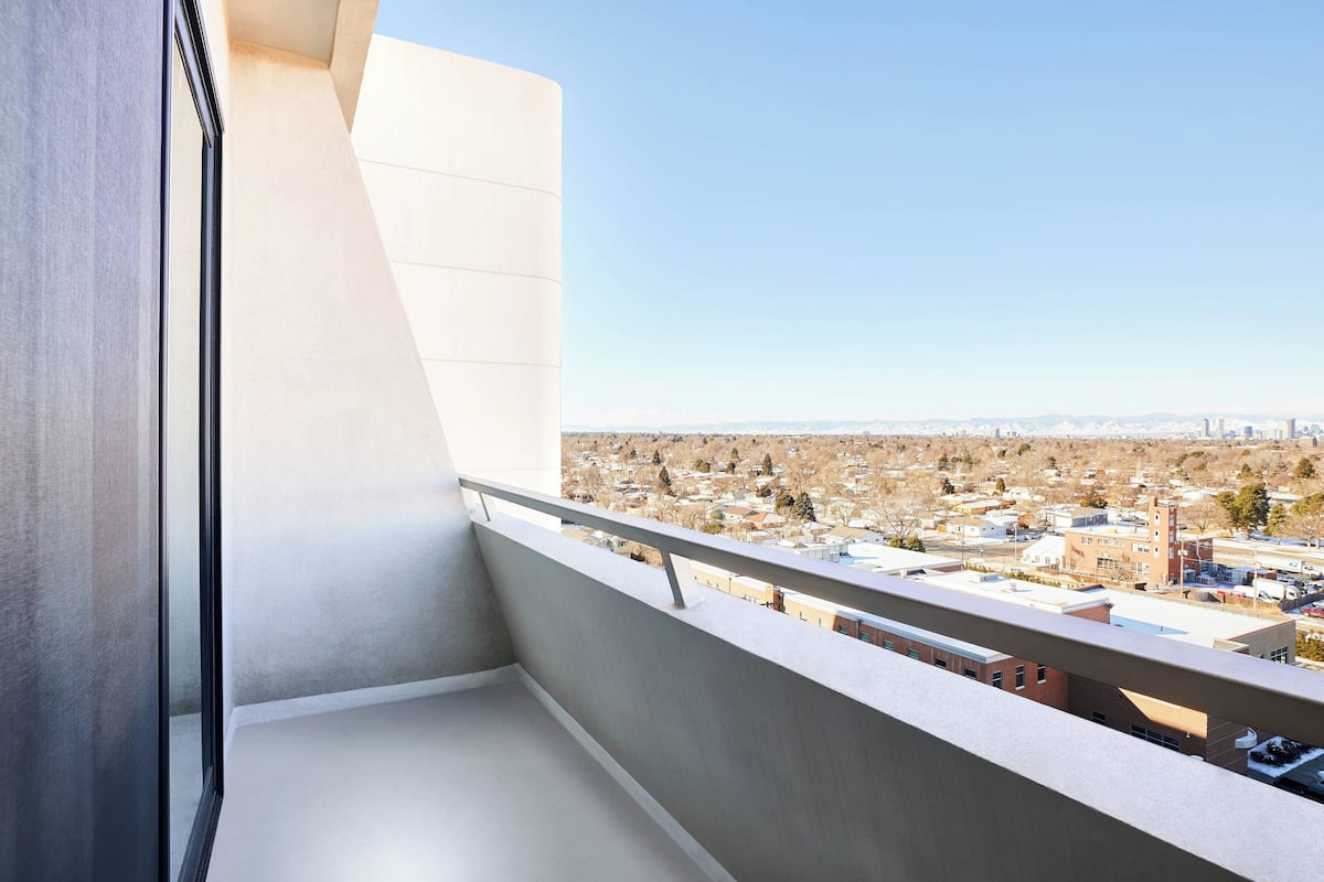 A balcony with a city view, a railing, and a modern building facade.