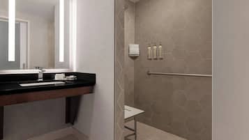 Een moderne badkamer met een zwart aanrechtblad, een wastafel, een spiegel en een douchegedeelte met honingraatmozaïek.