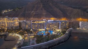 Un resort con varios edificios hoteleros, una amplia piscina y una zona de playa.