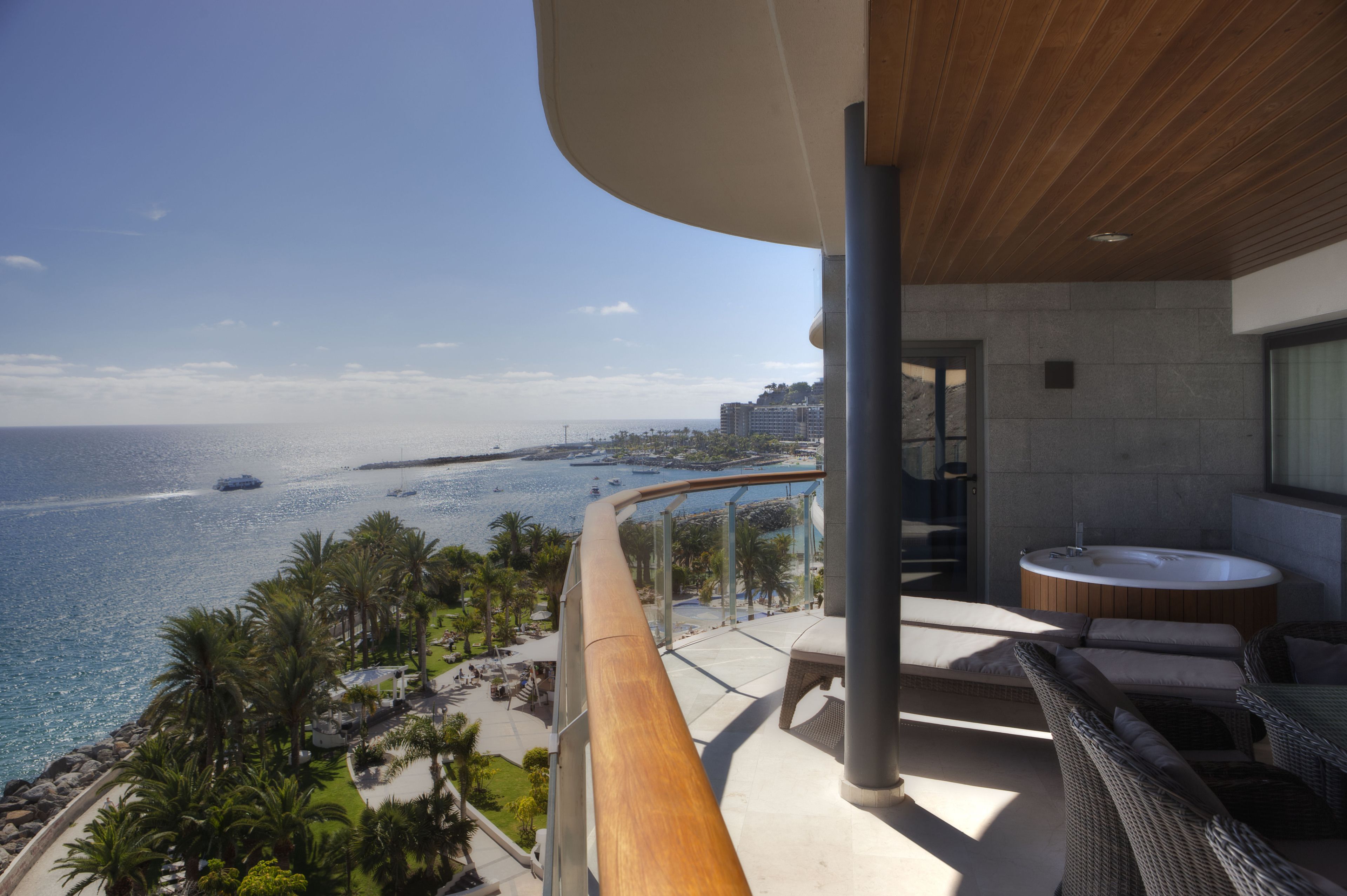 A balcony with a view of the sea and a hot tub.