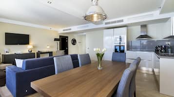 Una cocina moderna con una mesa de comedor de madera, un horno empotrado y un microondas.