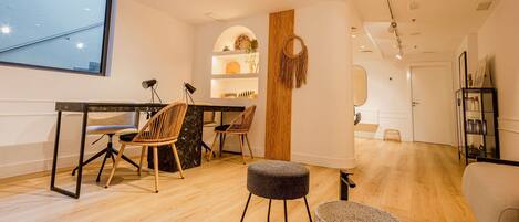 Un salon moderne avec un coin repas, un plancher en bois et une grande fenêtre.