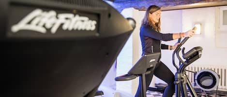 A person using an elliptical machine in a room with a checkered floor and a radiator.
