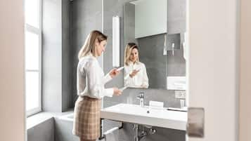 Une salle de bain moderne avec un grand miroir, un lavabo et une fenêtre.