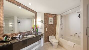 Un baño moderno con un espejo grande, lavamanos dobles, inodoro, bañera y ducha.