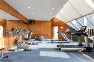 A gym with treadmills, elliptical machines, and weight equipment.