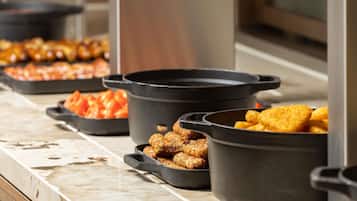 A buffet with various dishes in black serving containers.