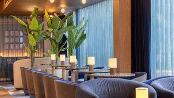 Un espace de détente moderne, doté de sièges, de tables et d’un éclairage d’ambiance.