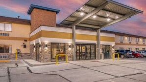 A hotel entrance with a covered walkway, stone facade, and a parking lot. - Comfort Inn Near Kokomo Speedway (Kokomo)