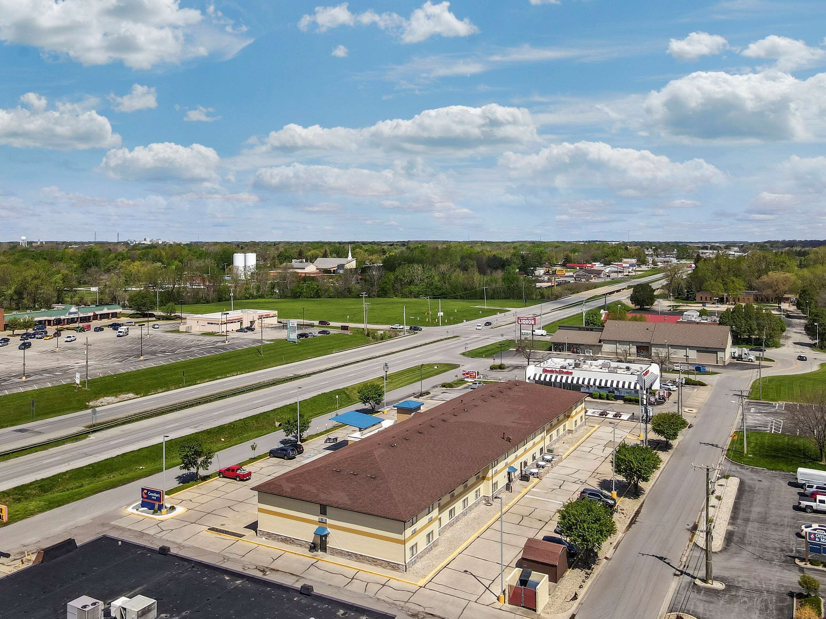 A large industrial building with a flat roof and a parking lot.