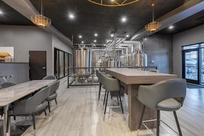 A modern kitchen with stainless steel appliances, a long wooden counter, and bar stools.