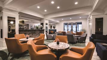 Un hall d’entrée avec des espaces salon, un bar et une cheminée.