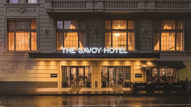 Das Savoy Hotel in der Little Collins Straße, mit klassischer Architektur, großen Fenstern und einem markanten Eingang.