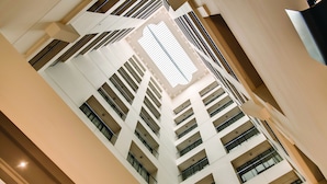 Ein Hochhaus mit mehreren Stockwerken, großen Fenstern und einem zentralen Atrium.