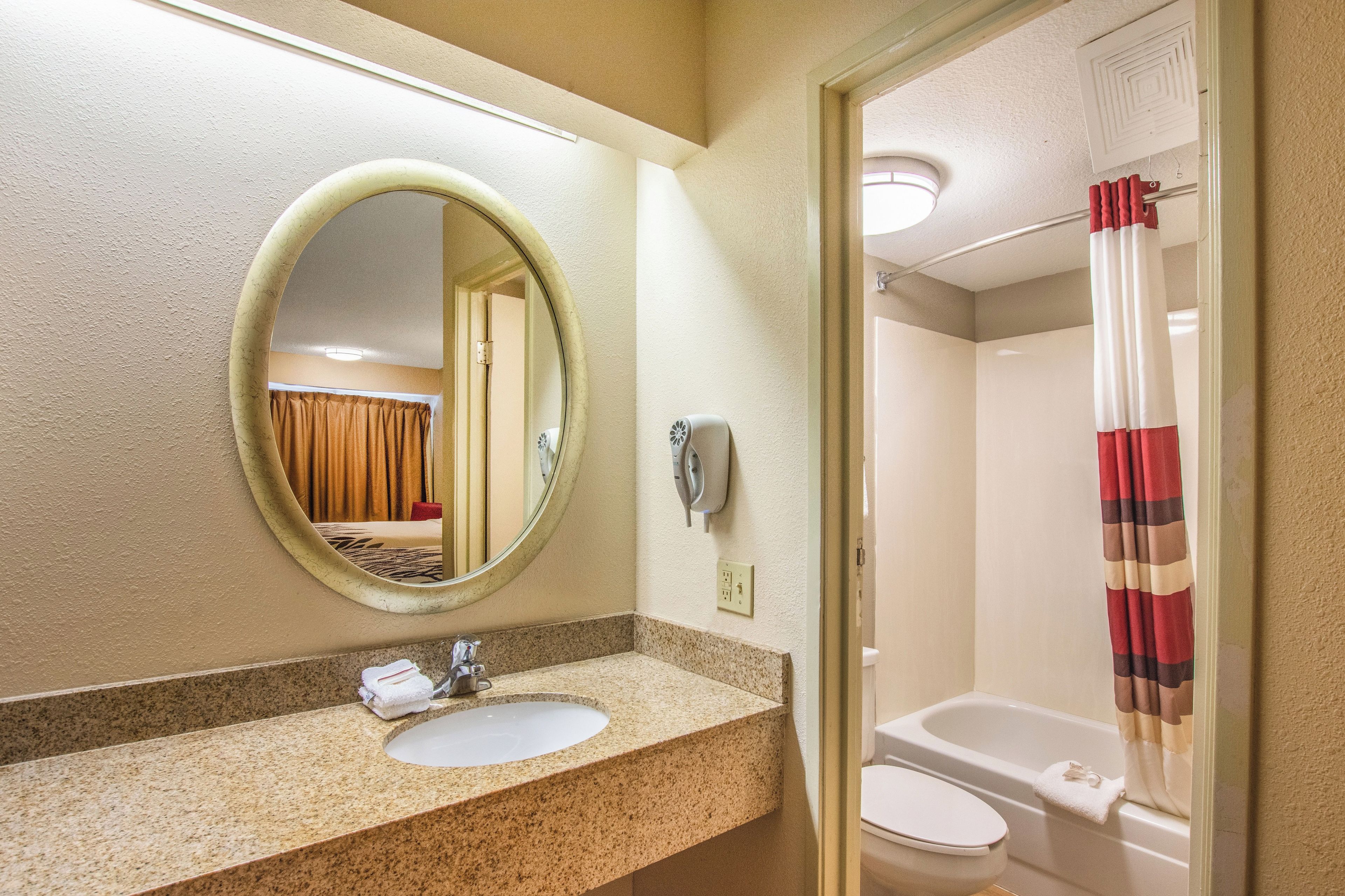 A bathroom with a sink, mirror, and toilet.