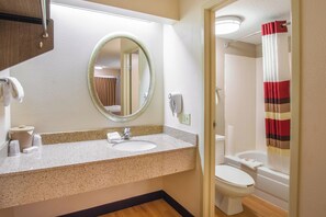 Ein Badezimmer mit Waschbecken, Spiegel, Toilette und Duschvorhang.