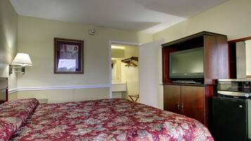A hotel room with a bed, a television, a microwave, and a wardrobe.