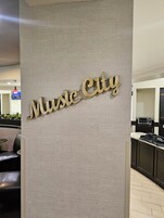 A wall with the words 'Music City' in a wooden font.