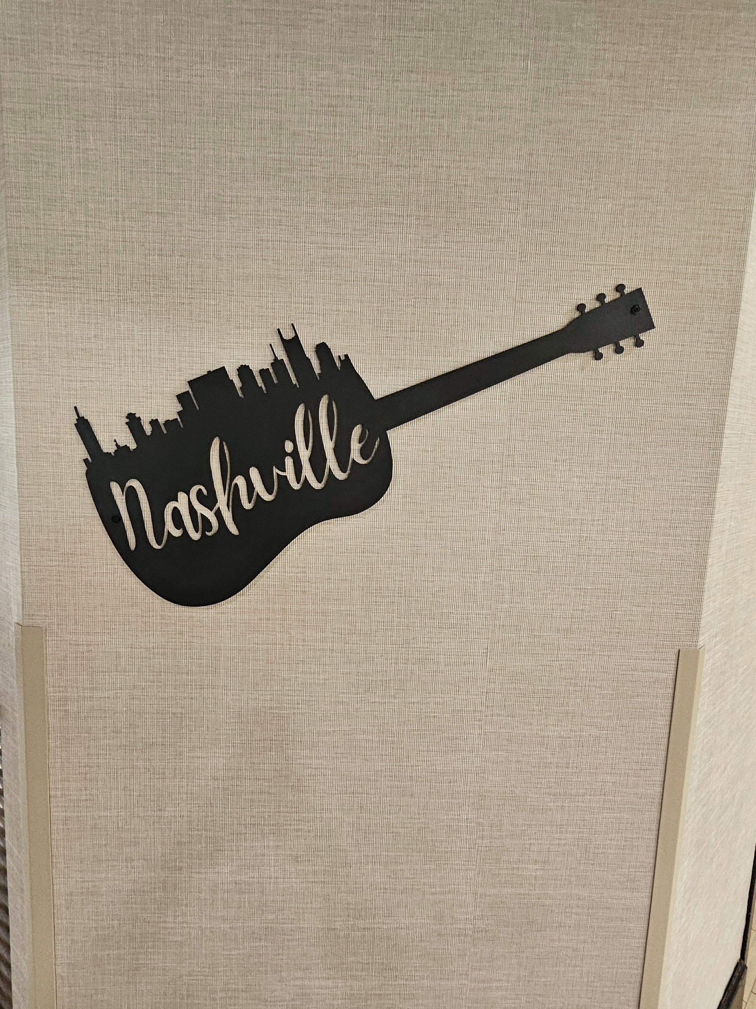 A guitar-shaped sign with the word 'Nashville' on it.