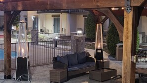 An outdoor patio with a pergola, seating area, and a pool in the background. - Club - Hotel Nashville Inn & Suites (Nashville)